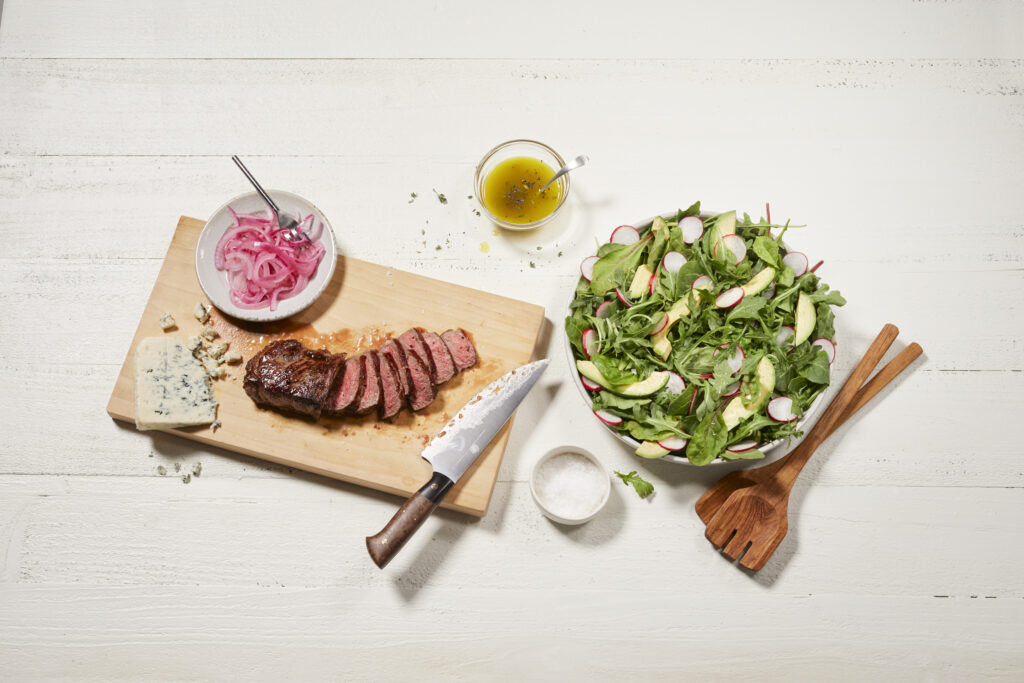 New York strip steak tabletop food styling salad